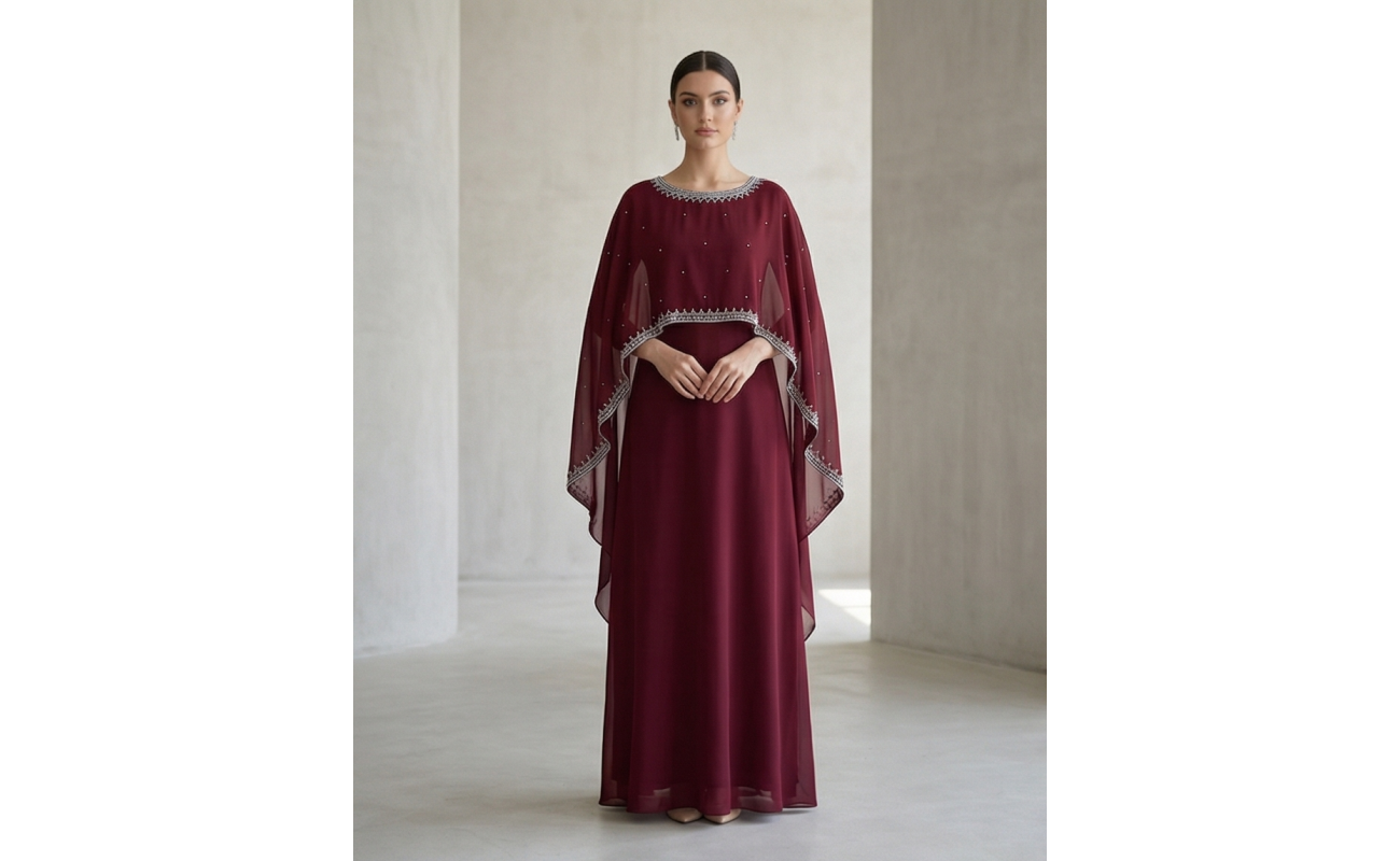 Woman wearing a deep burgundy shamoz silk maxi dress with a separate embroidered cape overlay and a floor-length A-line skirt.