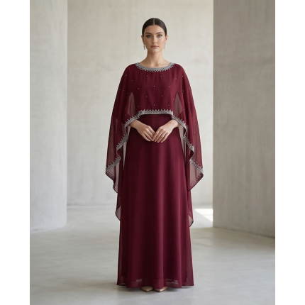 Woman wearing a deep burgundy shamoz silk maxi dress with a separate embroidered cape overlay and a floor-length A-line skirt.