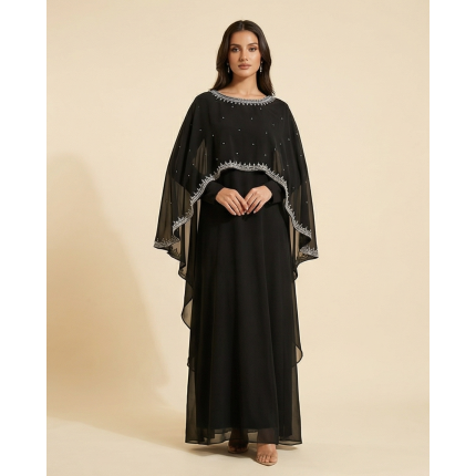 Woman modeling a luxury black shamoz silk maxi dress with a separate sheer cape overlay featuring silver embroidery.