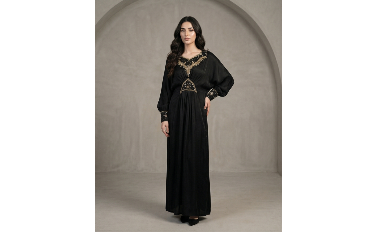 Woman modeling a luxurious black cotton lava kaftan dress featuring gold embroidery on the neck, waist, and cuffs.