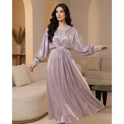 A shimmering pearl-pink cotton lava kaftan dress with silver embroidered neckline and cuffs, modeled in a minimalist setting.