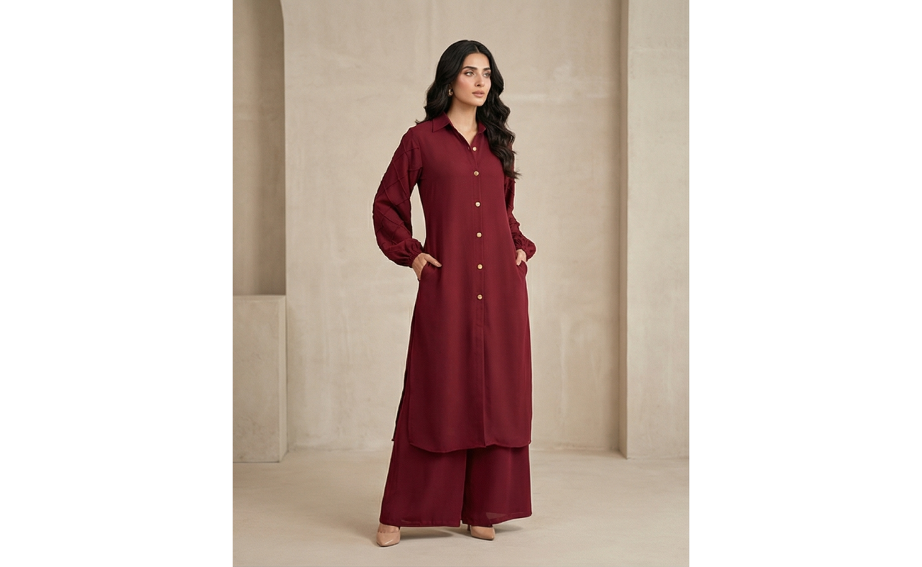 Woman walking in a minimalist corridor wearing a rich burgundy sheesha georgette co-ord set with a long tunic and wide-leg trousers.