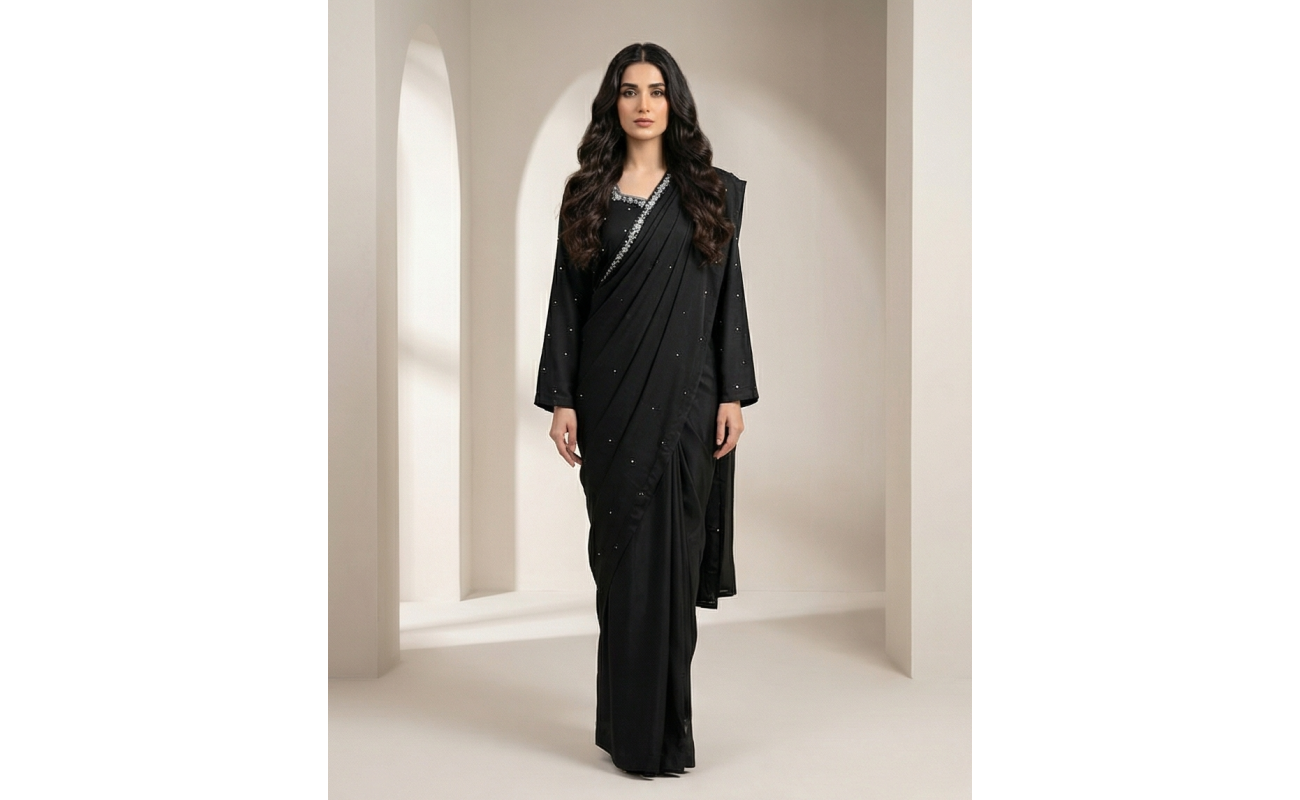 Woman modeling a stunning black shamooz silk sari with delicate silver embellishments along the border.
