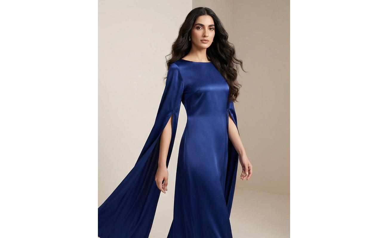 : Woman wearing a stunning royal blue shamoos silk maxi dress with dramatic long split sleeves and a boat neckline.