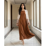 Woman modeling a rich terracotta-brown cotton jersey maxi dress with a white shrug overlay featuring brown floral and polka dot patterns.
