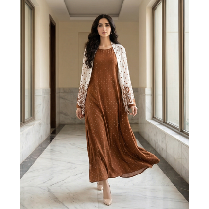 Woman modeling a rich terracotta-brown cotton jersey maxi dress with a white shrug overlay featuring brown floral and polka dot patterns.