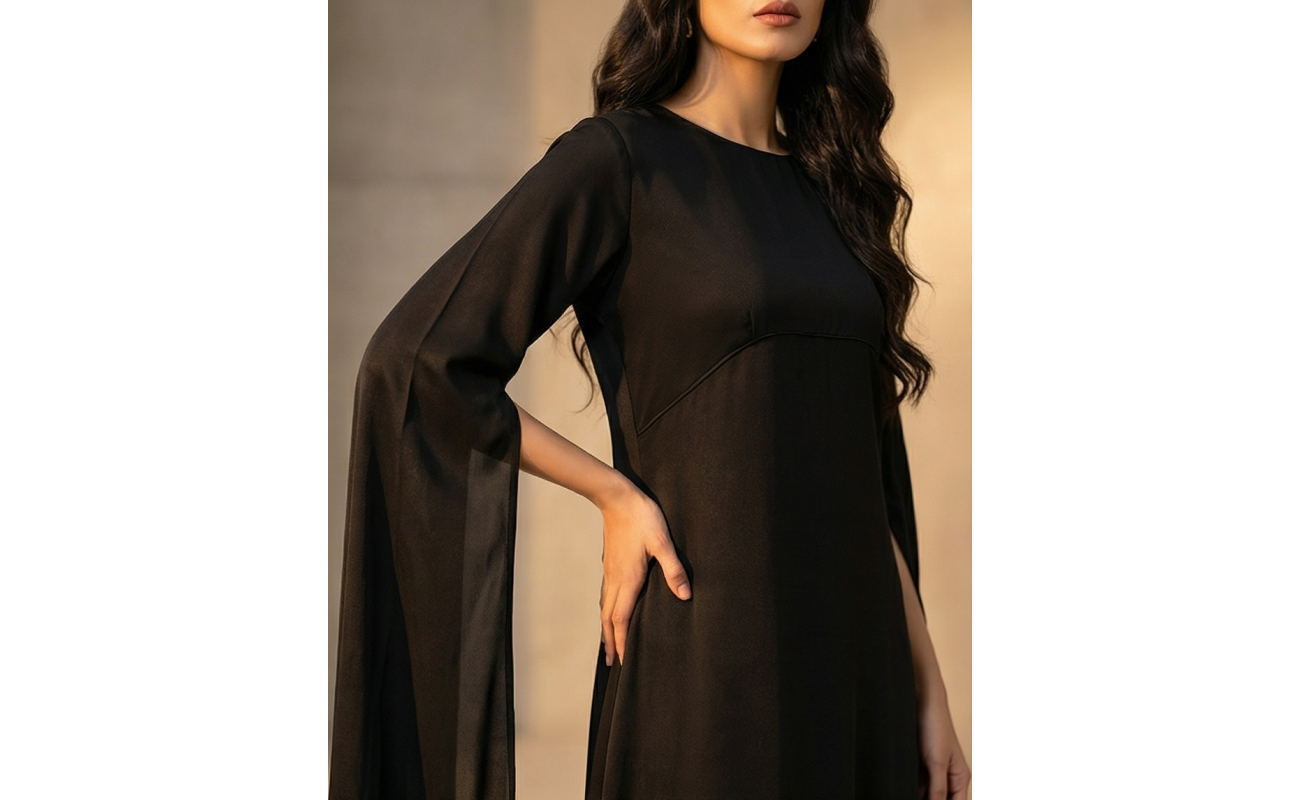 Woman in a high-fashion black shamoos silk maxi dress with long split-sleeve cape details and a modest neckline.
