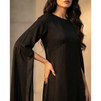 Woman in a high-fashion black shamoos silk maxi dress with long split-sleeve cape details and a modest neckline.