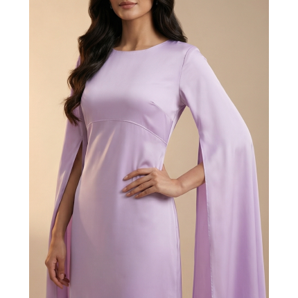 Woman wearing a dreamy lavender shamoos silk maxi dress with long split-sleeve cape details and a sophisticated boat neckline.