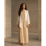 Woman wearing a beige cotton jersey maxi dress with a white and gold floral printed shrug overlay.